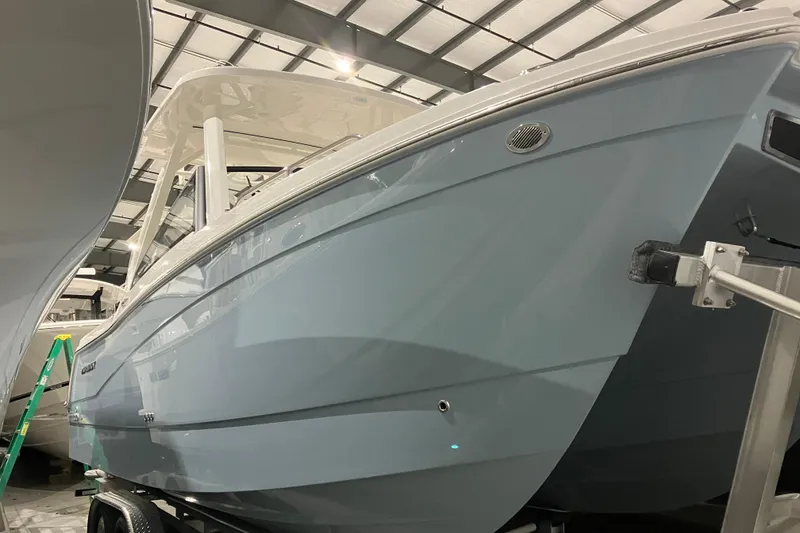 Slide: The Image of 2026 World Cat 265 DC-X boat in showroom, sleek design, blue hull. - 5