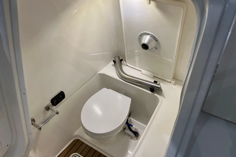 Slide: The Image of Interior of 2026 World Cat 265 DC-X boat, featuring a compact marine toilet. - 31