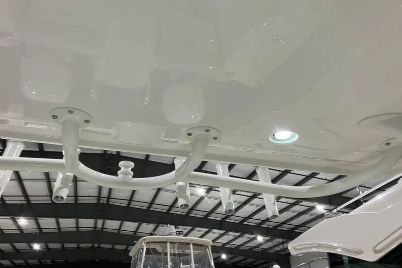 Slide: The Image of 2026 World Cat 265 DC-X boat interior with rod holders and lighting in a showroom. - 24