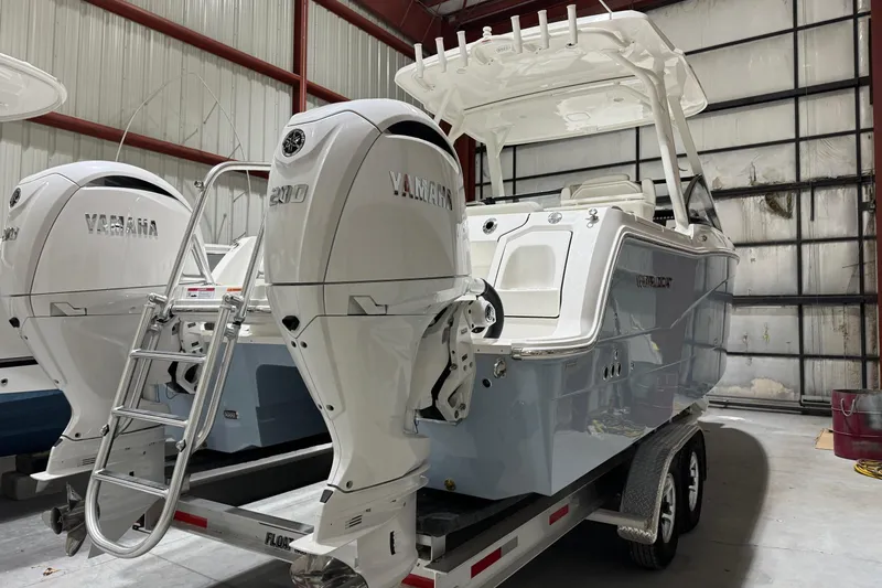 Slide: The Image of 2026 World Cat 265 DC-X boat with twin Yamaha engines in a storage facility. - 6