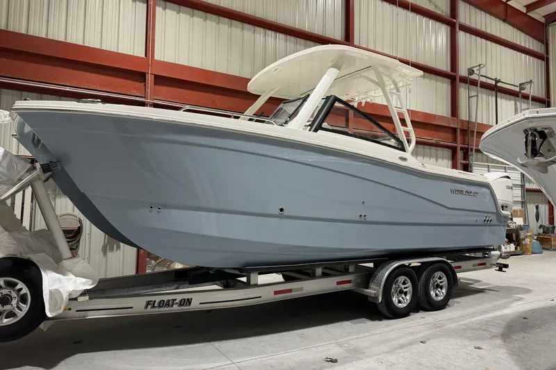 Slide: The Image of 2026 World Cat 265 DC-X boat on trailer in warehouse setting. - 2
