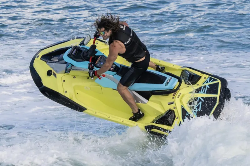 Slide: The Image of 2025 Yamaha WaveRunner JetBlaster PRO 3-Up in showroom, vibrant yellow and blue design. - 1