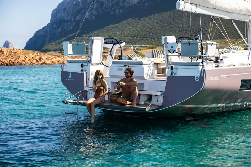 Slide: The Image of Couple relaxing on a 2026 Beneteau Oceanis 52 yacht in scenic coastal waters. - 16