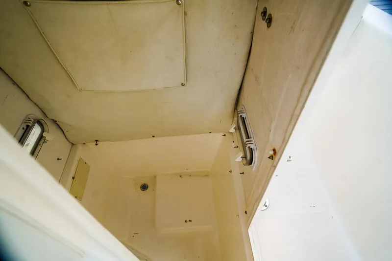 Slide: The Image of Interior cabin of a 1999 Century 2600 CC boat, featuring white walls and ceiling. - 9