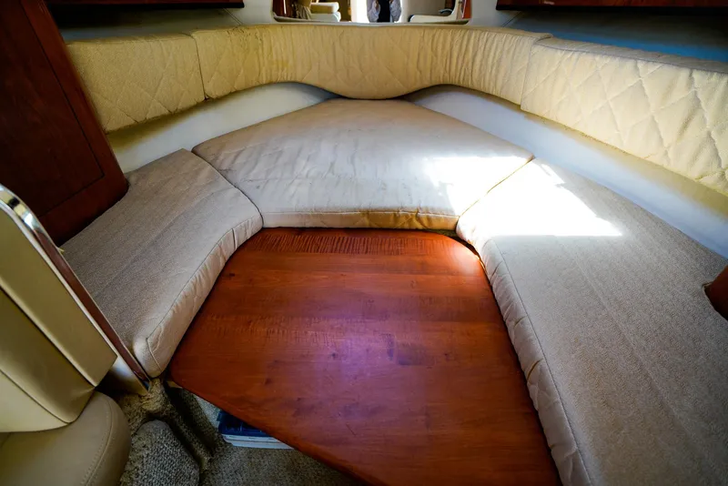 Slide: The Image of Interior cabin of 2007 Sea Ray 280 Sundancer with cushioned seating and wooden table. - 23