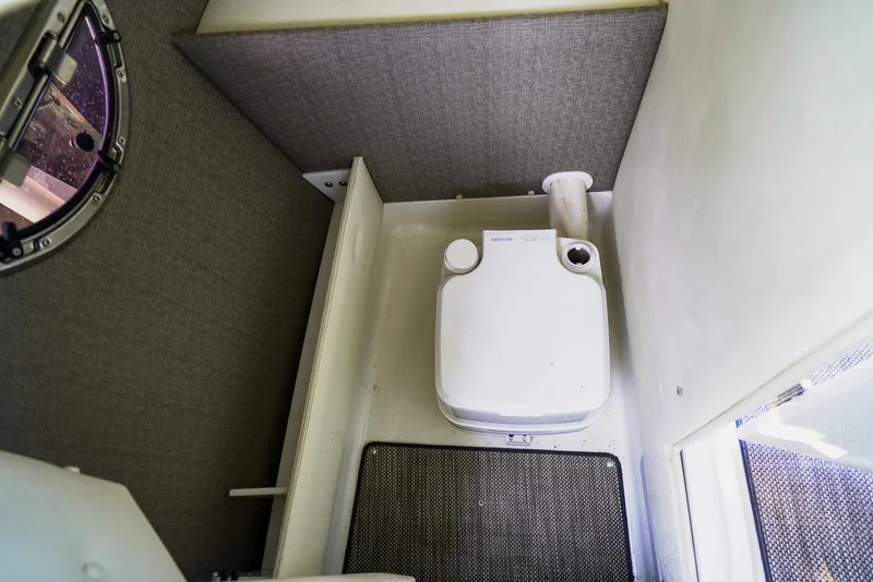 Slide: The Image of 2019 Cobalt 23SC boat interior with compact marine toilet. - 13