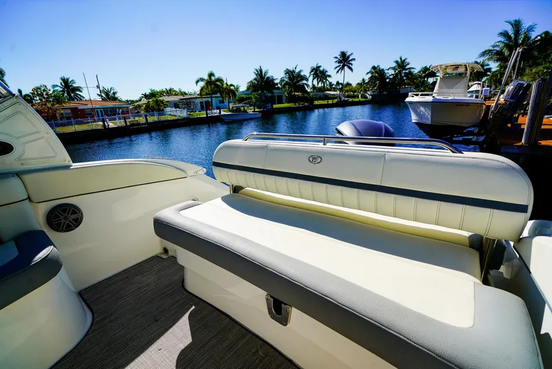 Slide: The Image of 2019 Cobalt 23SC boat interior with seating, docked by a scenic waterfront. - 5