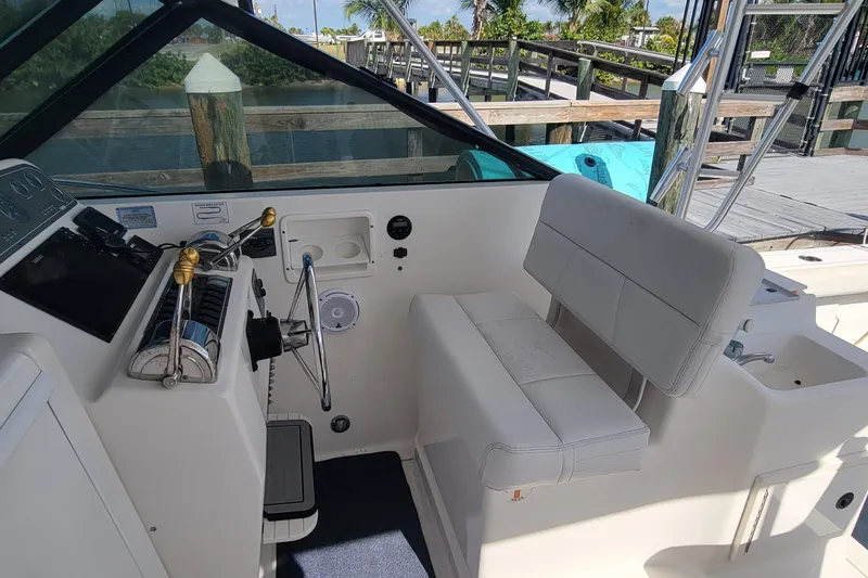 Slide: The Image of 2006 Tiara Yachts 2900 Open Classic helm with white seating and control panel. - 13