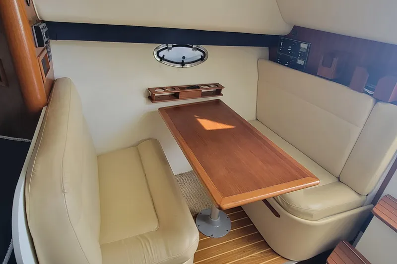 Slide: The Image of 2006 Tiara Yachts 2900 Open Classic interior with beige seating and wooden table. - 15