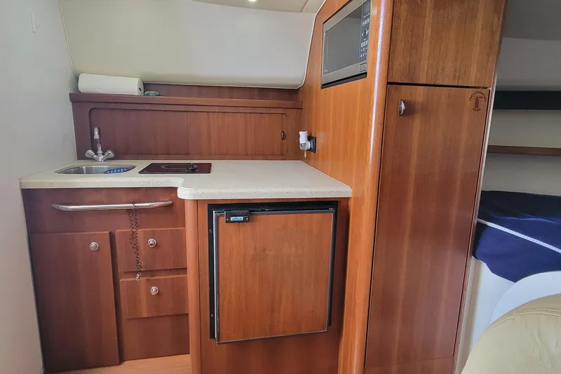 Slide: The Image of 2006 Tiara Yachts 2900 Open Classic interior kitchen with wood cabinetry and compact appliances. - 16