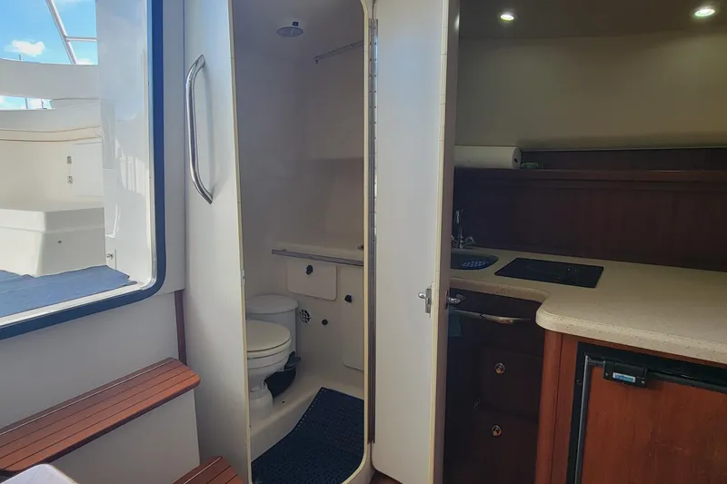 Slide: The Image of 2006 Tiara Yachts 2900 Open Classic interior with kitchenette and bathroom. - 17