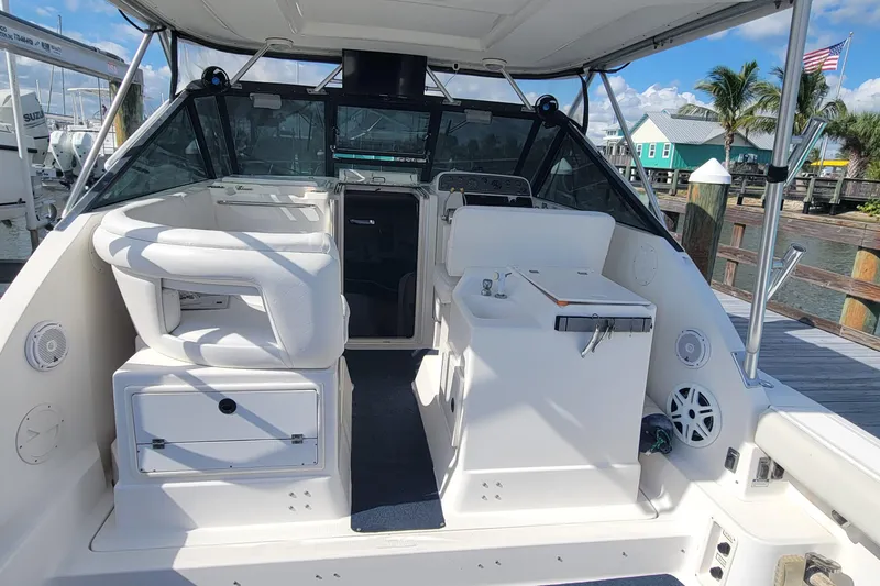 Slide: The Image of 2006 Tiara Yachts 2900 Open Classic boat interior at dock, featuring seating and helm. - 7