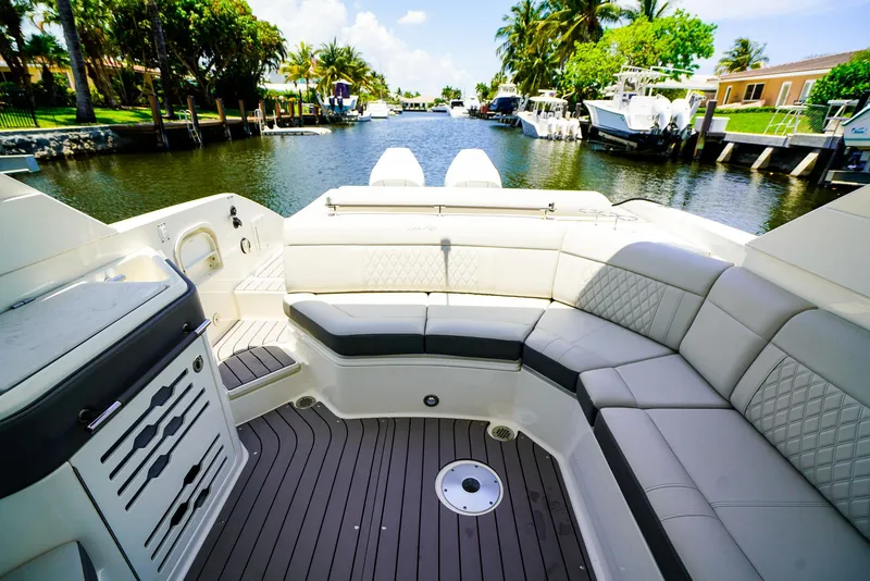 Slide: The Image of 2022 Sea Ray SLX 310 OB boat interior with luxurious seating and scenic canal view. - 11