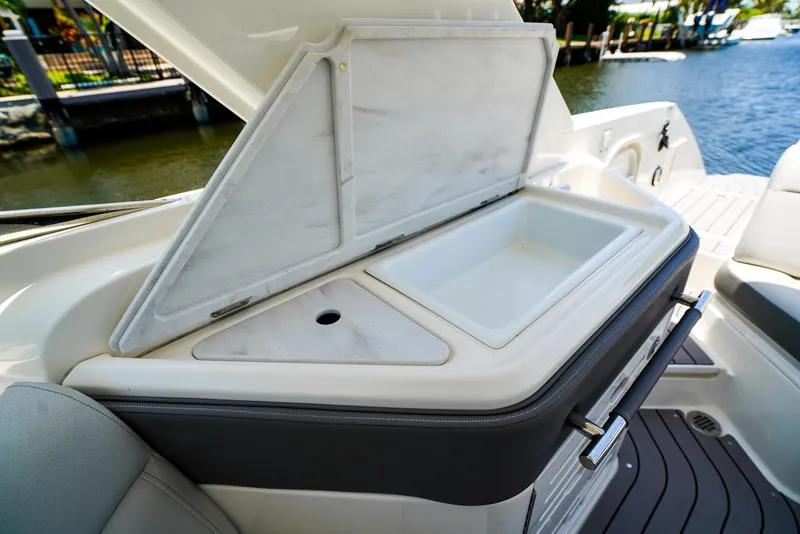 Slide: The Image of 2022 Sea Ray SLX 310 OB boat with open storage compartment and sink. - 12