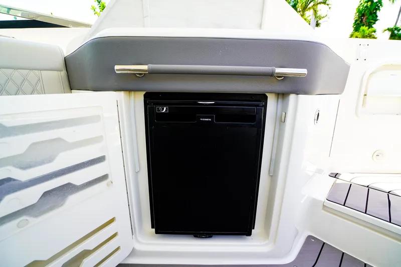 Slide: The Image of 2022 Sea Ray SLX 310 OB boat interior with built-in mini fridge. - 13