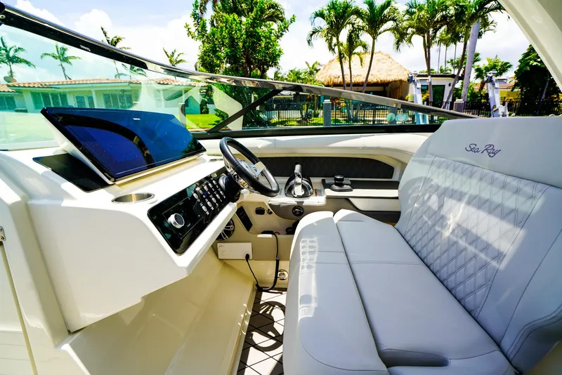 Slide: The Image of 2022 Sea Ray SLX 310 OB boat interior with luxurious seating and modern dashboard. - 17