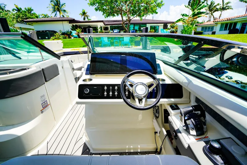 Slide: The Image of 2022 Sea Ray SLX 310 OB boat cockpit with modern steering and controls, tropical background. - 19