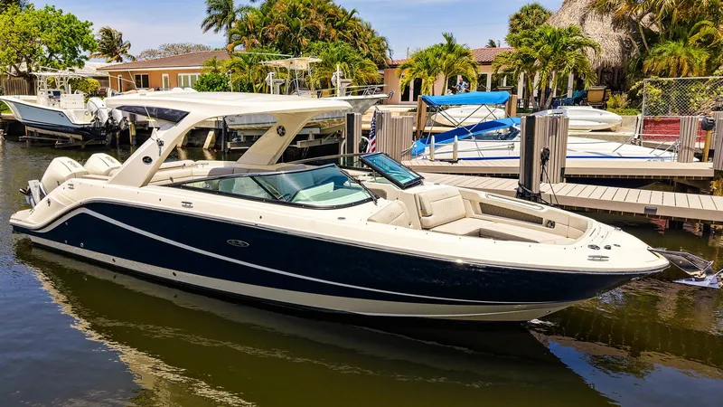 Slide: The Image of 2022 Sea Ray SLX 310 OB boat docked in a sunny marina setting. - 30