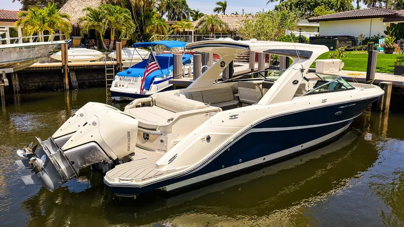 Slide: The Image of 2022 Sea Ray SLX 310 OB boat docked in a sunny marina setting. - 31