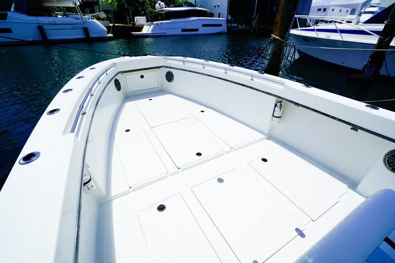 Slide: The Image of 2001 Whitewater 28 Open boat deck with storage compartments, docked near other boats. - 15