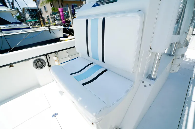 Slide: The Image of Whitewater 28 Open 2001 boat seating with striped cushions, docked in a marina. - 16