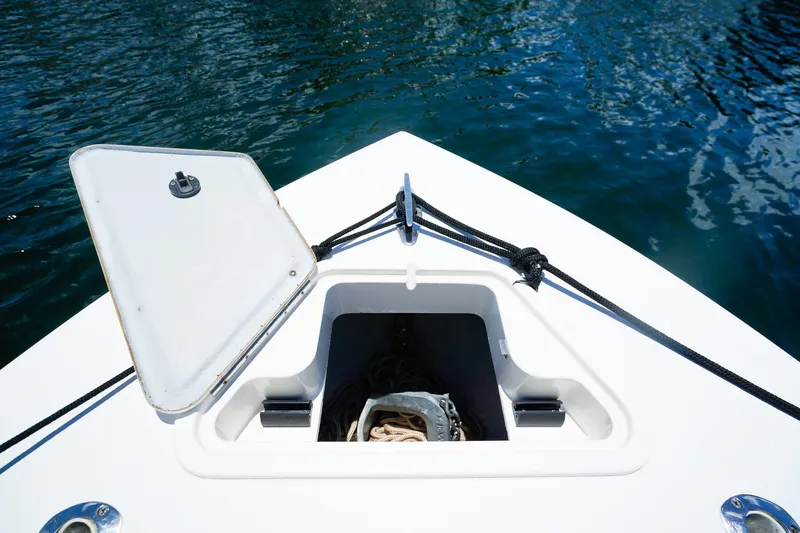 Slide: The Image of Open anchor hatch on 2001 Whitewater 28 Open boat, docked on calm water. - 18