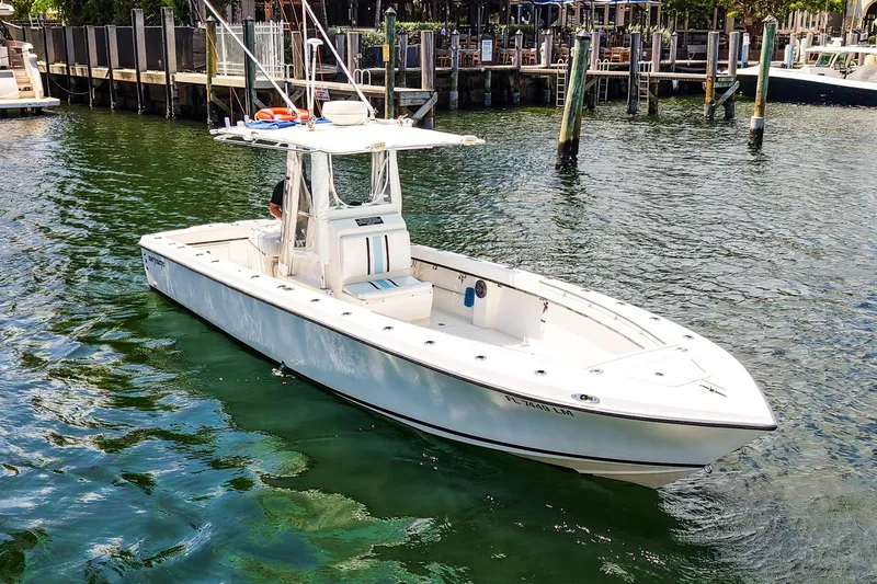 Slide: The Image of 2001 Whitewater 28 Open boat docked in a marina, surrounded by calm water. - 2