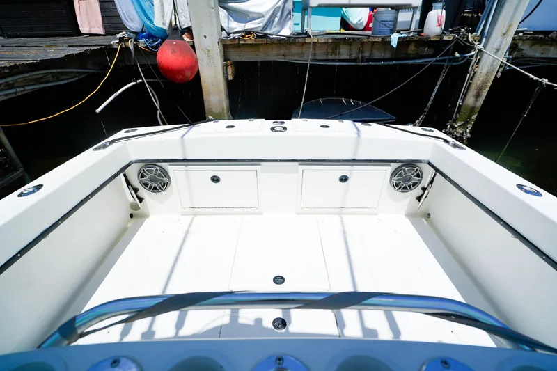 Slide: The Image of 2001 Whitewater 28 Open boat interior with storage compartments and speakers at dock. - 4