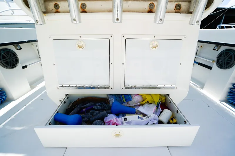Slide: The Image of Storage compartment on a 2001 Whitewater 28 Open boat, filled with various items. - 8
