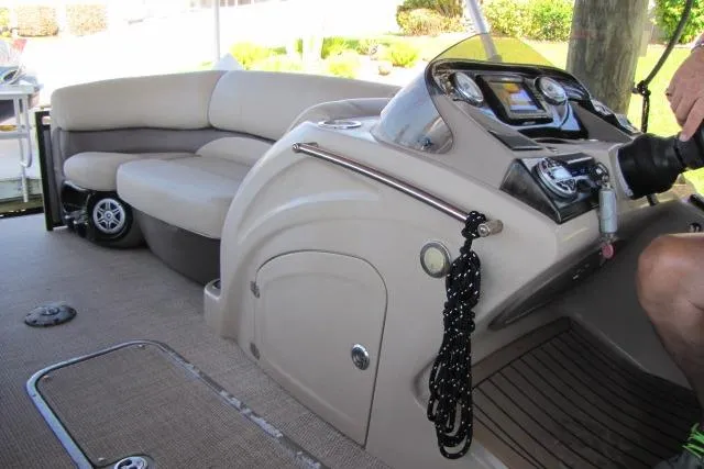 Slide: The Image of 2018 Regency 220 DL3 boat interior with beige seating and modern dashboard controls. - 10