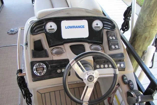 Slide: The Image of 2018 Regency 220 DL3 boat dashboard with Lowrance display and steering wheel. - 13