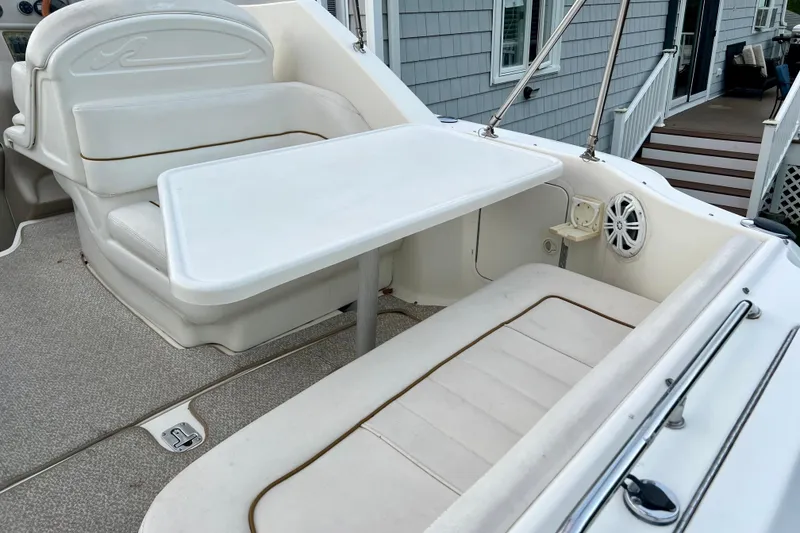 Slide: The Image of 2000 Sea Ray 270 Sundancer boat interior with seating and table setup. - 12