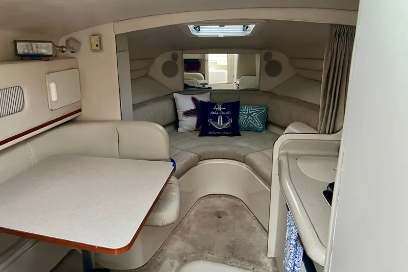 Slide: The Image of Interior of 2000 Sea Ray 270 Sundancer boat with cozy seating and nautical decor. - 13