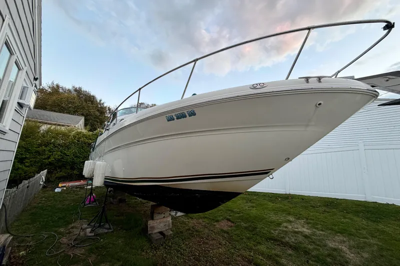 Slide: The Image of 2000 Sea Ray 270 Sundancer boat on stands in a yard, side view. - 4