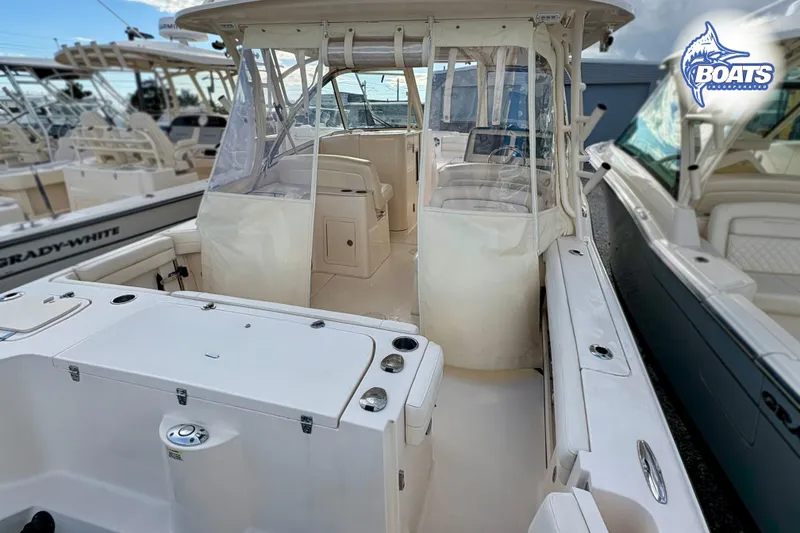 Slide: The Image of 2021 Grady-White Freedom 325 boat interior with seating and helm, docked among other boats. - 18