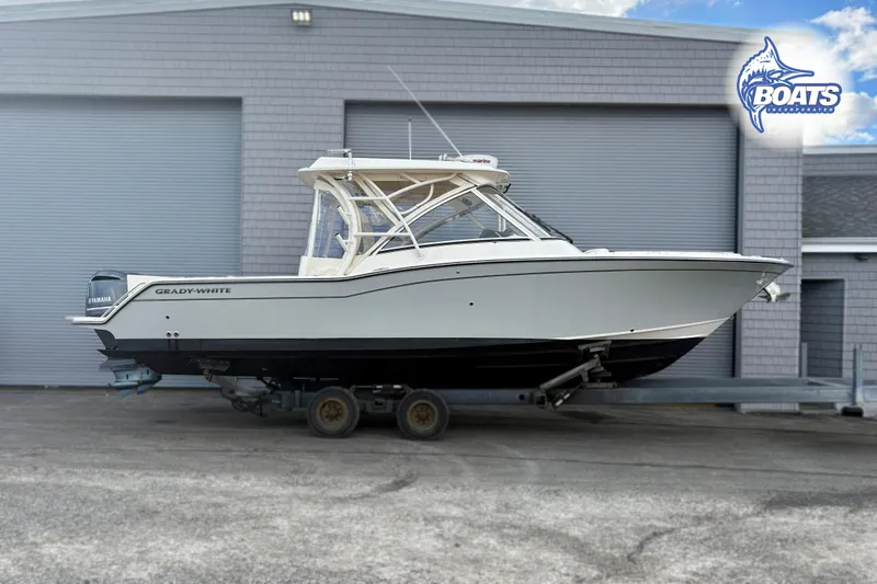 Slide: The Image of 2021 Grady-White Freedom 325 boat on trailer, parked outside a building. - 2