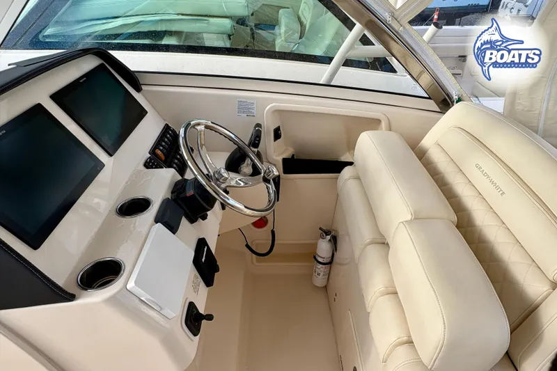 Slide: The Image of 2021 Grady-White Freedom 325 boat interior with helm, dual screens, and plush seating. - 9