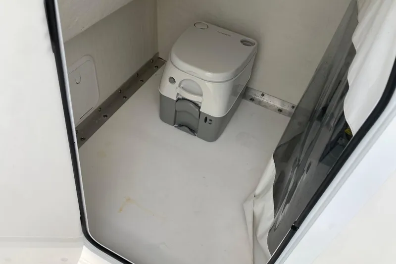 Slide: The Image of 2021 Twin Vee 280 GFX CC boat interior with compact portable toilet. - 14