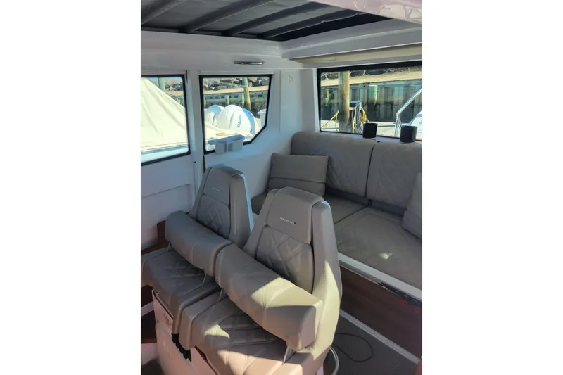 Slide: The Image of 2023 Axopar 28 Cabin interior with plush seating and large windows. - 15