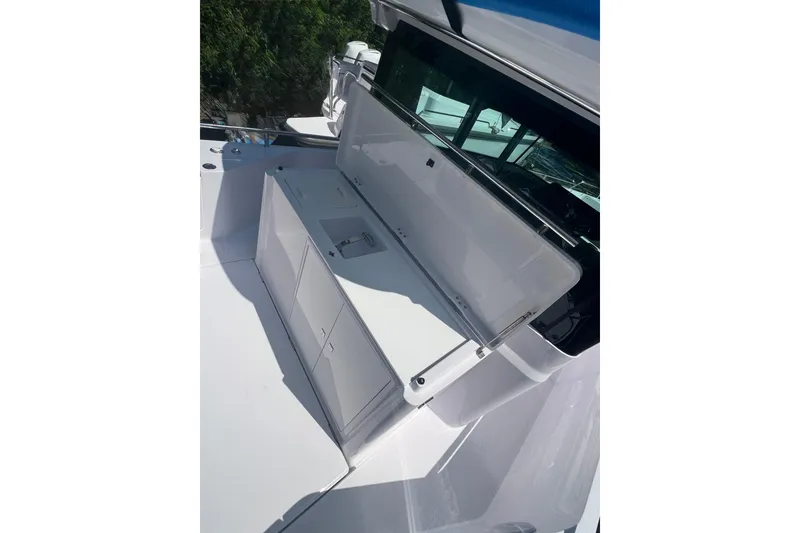 Slide: The Image of 2023 Axopar 28 Cabin Wet Bar with open storage compartment on deck. - 6