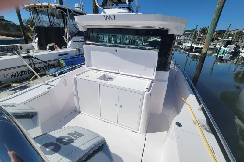 Slide: The Image of 2023 Axopar 28 Cabin boat docked, featuring sleek design and spacious deck area. - 9