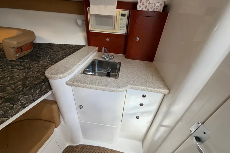 Slide: The Image of 2008 Intrepid 350 Center Console cabin with sink, microwave, and storage cabinets. - 35
