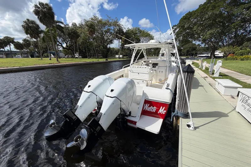 Slide: The Image of 2008 Intrepid 350 Center Console boat docked by a scenic canal under a blue sky. - 8