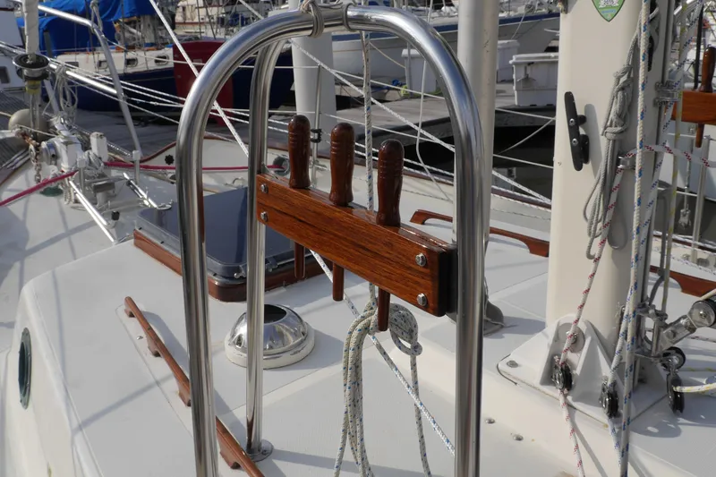Slide: The Image of 1976 Westsail 32 sailboat deck with rigging and wooden trim in marina setting. - 11