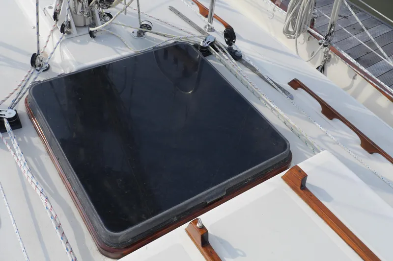 Slide: The Image of 1976 Westsail 32 sailboat in marina, featuring rigging and wooden cleats. - 15