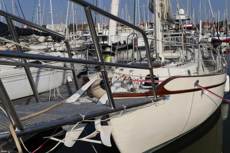 Slide: The Image of 1976 Westsail 32 sailboat docked in a marina, surrounded by other boats. - 2