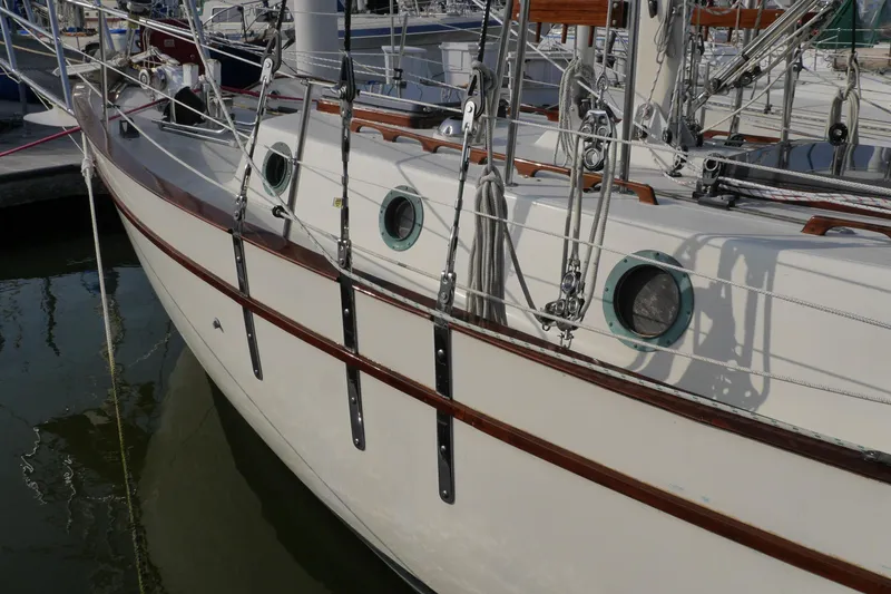 Slide: The Image of 1976 Westsail 32 sailboat docked, showcasing rigging and portholes. - 3