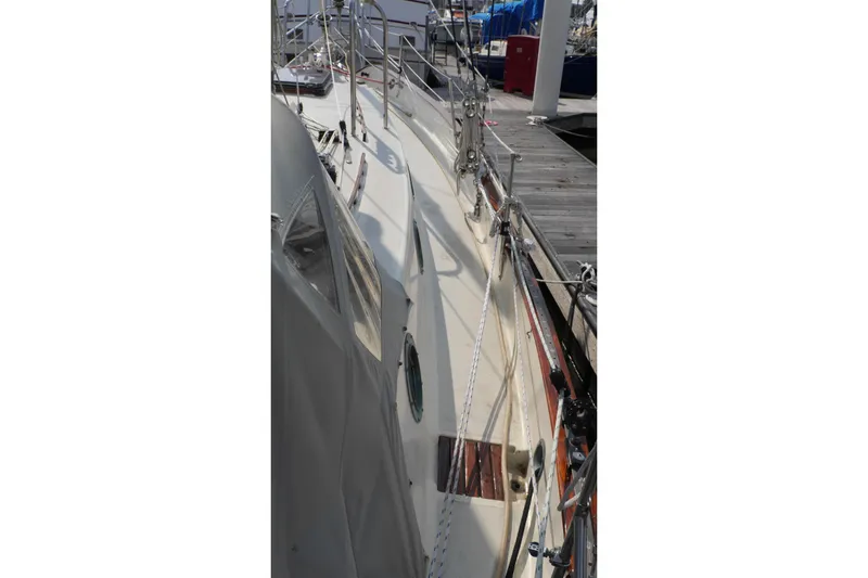 Slide: The Image of 1976 Westsail 32 yacht interior kitchen with wooden cabinetry and stainless steel sink. - 47