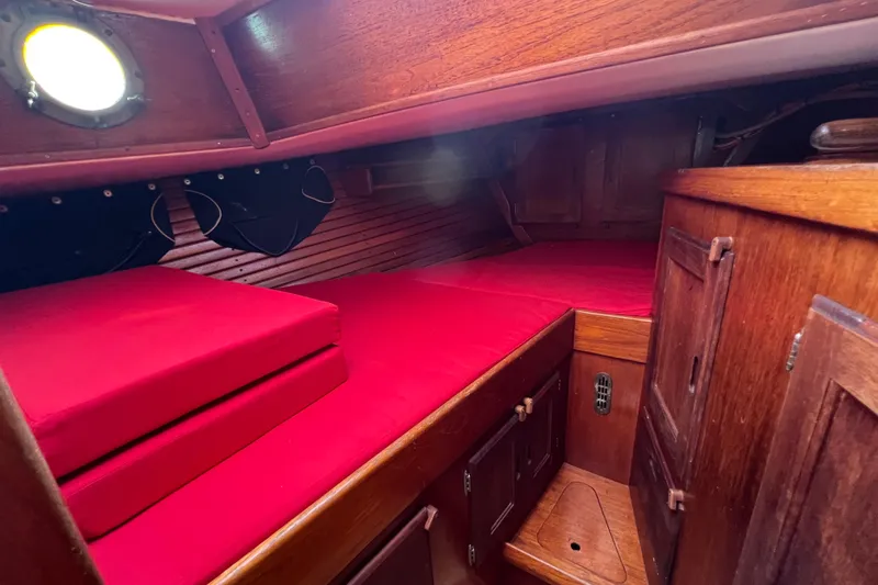 Slide: The Image of 1976 Westsail 32 yacht interior with wooden cabinetry and compact kitchen area. - 48