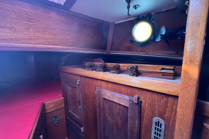 Slide: The Image of Interior of a 1976 Westsail 32 sailboat with wooden shelves and storage jars. - 49